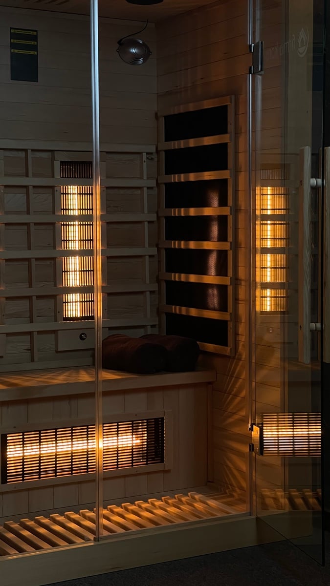 Infrared sauna: a wooden cabin with a glass door and heating panels